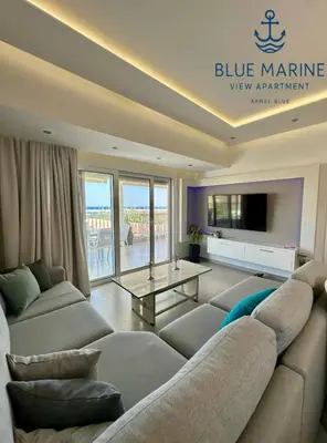 a large living room with a couch and a tv at Blue Marine View Apartment in Rhodes Town