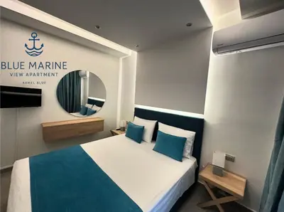 a bedroom with a blue marlin sign and a bed at Blue Marine View Apartment in Rhodes Town