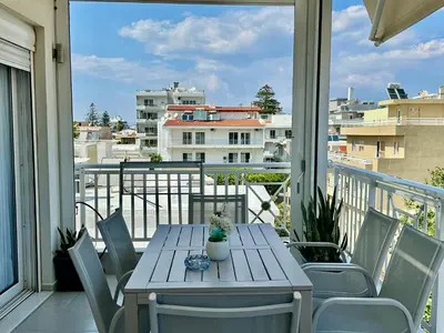 a table and chairs on a balcony with a view at Blue Marine View Apartment in Rhodes Town