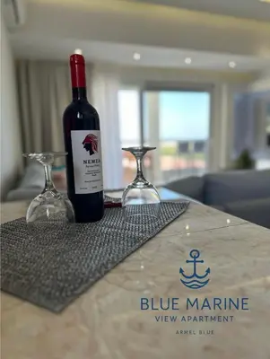 a bottle of wine sitting on a table with two glasses at Blue Marine View Apartment in Rhodes Town
