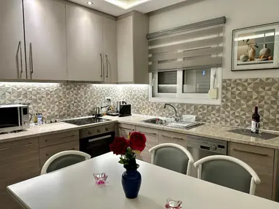 a kitchen with a table with a vase of roses on it at Blue Marine View Apartment in Rhodes Town