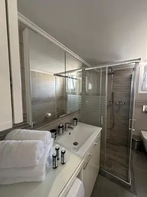 a white bathroom with a sink and a shower at Blue Marine View Apartment in Rhodes Town
