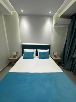 a bedroom with a blue and white bed with two blue pillows at Blue Marine View Apartment in Rhodes Town