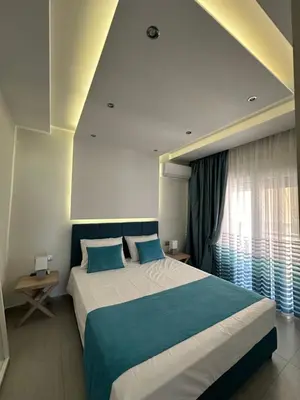 a bedroom with a large bed and a window at Blue Marine View Apartment in Rhodes Town