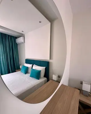 a bedroom with a bed with a round mirror at Blue Marine View Apartment in Rhodes Town