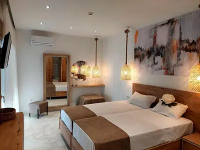 a bedroom with a large bed and a mirror at Alexa Luxury Suites in Afantou