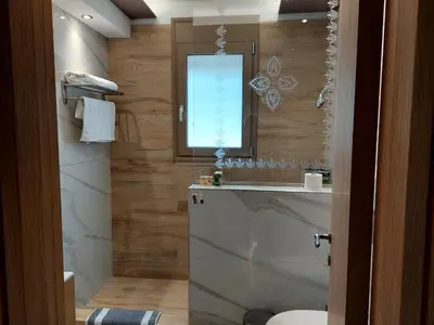 a bathroom with a sink and a toilet and a window at Alexa Luxury Suites in Afantou