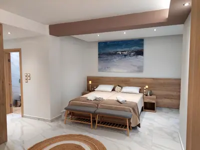 a bedroom with a large bed and a table at Alexa Luxury Suites in Afantou