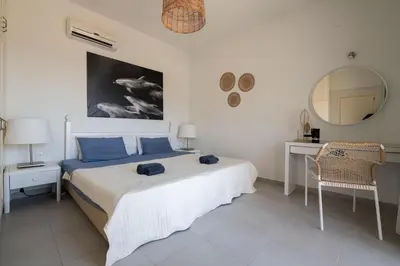 a bedroom with a bed and a table and a mirror at Bougan Villa in Lardos