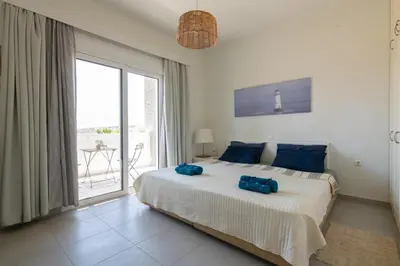 a bedroom with a large bed with blue pillows on it at Bougan Villa in Lardos