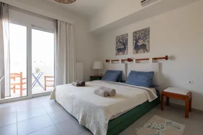 a bedroom with a bed with two stuffed animals on it at Bougan Villa in Lardos