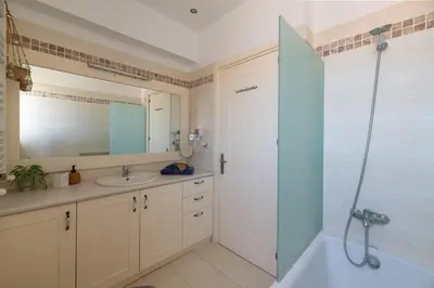 a bathroom with a tub and a sink and a shower at Bougan Villa in Lardos