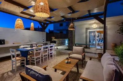 a patio with a bar and tables and chairs at Bougan Villa in Lardos