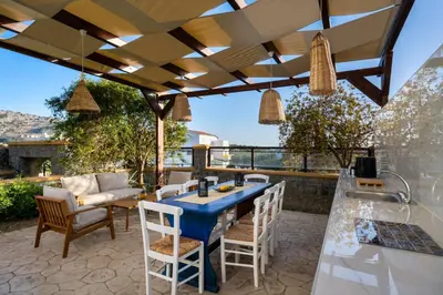 an outdoor patio with a blue table and chairs at Bougan Villa in Lardos