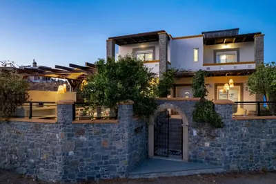a stone wall with a gate in front of a building at Bougan Villa in Lardos