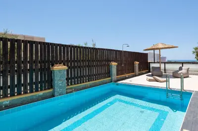 a swimming pool in front of a wooden fence at Bougan Villa in Lardos