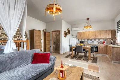 a living room with a blue couch and a kitchen at Παραδοσιακό Κατάλυμα ΑΜΒΩΝΑΣ in Émbonas