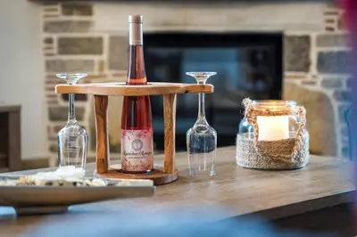 a bottle of wine and two glasses on a table at Παραδοσιακό Κατάλυμα ΑΜΒΩΝΑΣ in Émbonas