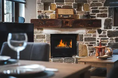 a fireplace in a restaurant with a table and a wine glass at Παραδοσιακό Κατάλυμα ΑΜΒΩΝΑΣ in Émbonas