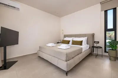 a bedroom with a bed and a flat screen tv at Mirena Luxury Living-Mirena Villa in Afantou