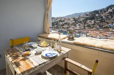 a table with food on it with a view of a city at kalosymi house,Symi in Symi