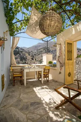 a patio with a table and chairs and a view at kalosymi house,Symi in Symi