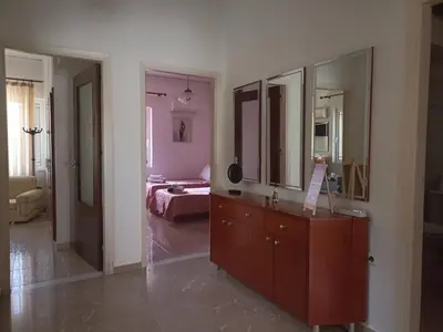 a bathroom with a dresser and a bedroom with a bed at Anastasia's Cozy Retreat in Ialyssos