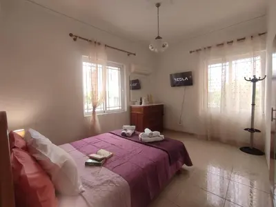 a bedroom with a purple bed with two towels on it at Anastasia's Cozy Retreat in Ialyssos