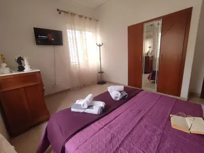a bedroom with a purple bed with towels on it at Anastasia's Cozy Retreat in Ialyssos