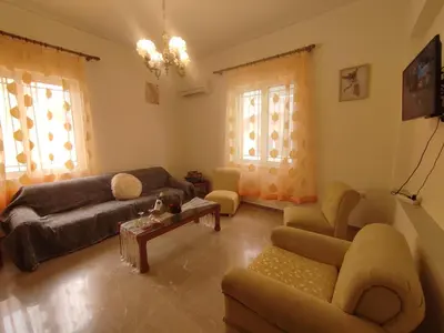 a living room with a couch and a table at Anastasia's Cozy Retreat in Ialyssos