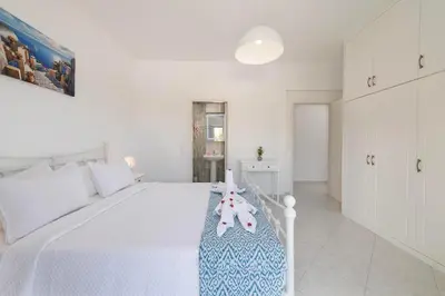 a white bedroom with a bed with a teddy bear on it at Nimo Paradise Estate in Paradeísion