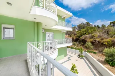 a balcony of a green building with white railings at Nimo Paradise Estate in Paradeísion