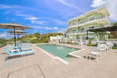 a house with a swimming pool with chairs and an umbrella at Nimo Paradise Estate in Paradeísion