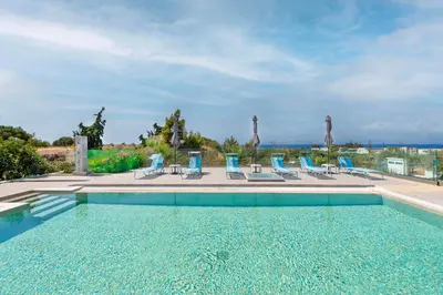 a swimming pool with blue lounge chairs at Nimo Paradise Estate in Paradeísion