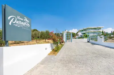 a sign for a hotel on the side of a sidewalk at Nimo Paradise Estate in Paradeísion