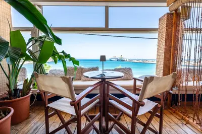 a table and two chairs in a room with a view of the ocean at La Terrazza Sul Mare in Rhodes Town