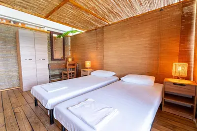 two beds in a room with wooden walls at La Terrazza Sul Mare in Rhodes Town