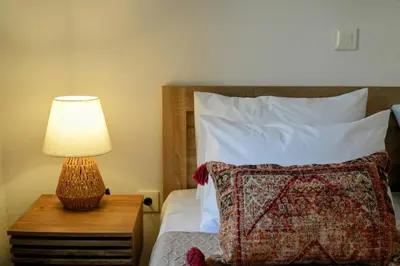a bedroom with a bed with a lamp on a table at Bella Vista II in Symi
