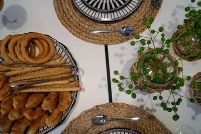 a table topped with plates of bread and spoons at Bella Vista II in Symi