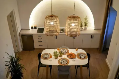 a kitchen with a white table and two chandeliers at Bella Vista II in Symi
