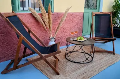 a pair of chairs and a table in front of a wall at Bella Vista II in Symi