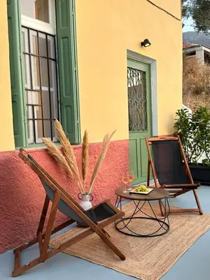 a patio with a table and a chair next to a building at Bella Vista II in Symi