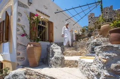 a woman walking down the stairs of a building at kalosymi studio, Symi in Symi