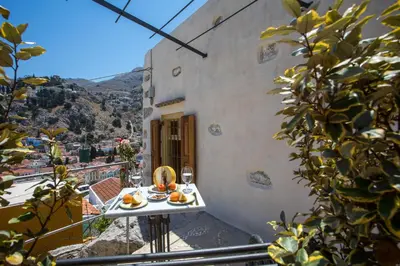 a table with oranges on it on a balcony at kalosymi studio, Symi in Symi
