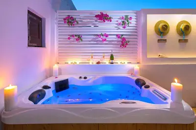 a bath tub in a room with candles and flowers at Lindos Allure Villa with Jacuzzi and Acropolis view!!! in Líndos