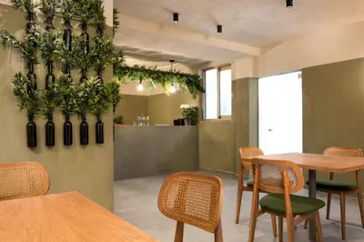a restaurant with wooden tables and chairs and plants on the wall at Açai Plant Based Hotel in Rhodes Town
