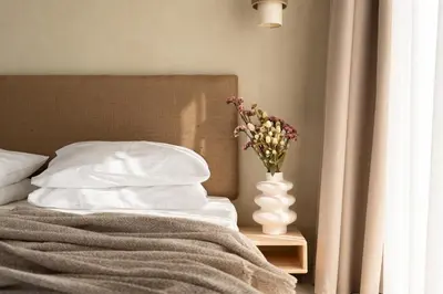 a bedroom with a bed with a vase of flowers on a table at Açai Plant Based Hotel in Rhodes Town