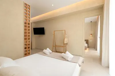 a bedroom with a white bed and a television at Açai Plant Based Hotel in Rhodes Town