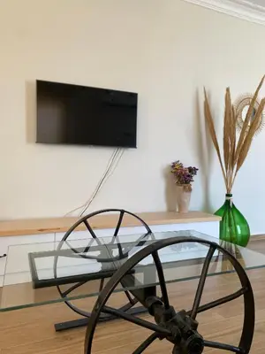 a glass coffee table with a tv on a wall at Bohemian Paradise Villa in Paradeísion