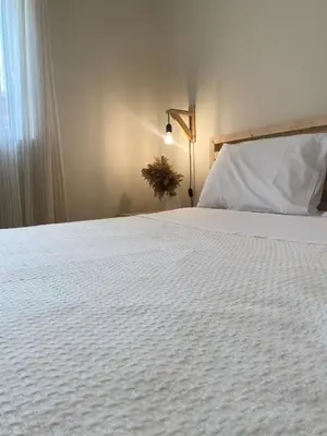 a bedroom with a bed with a white bedspread at Bohemian Paradise Villa in Paradeísion